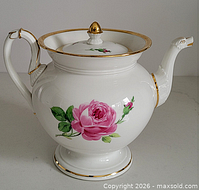 Left side view showing rose motif, handle, lid and spout
