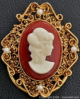 Front view of gold-tone cameo brooch with faux pearls