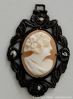 Front view cameo pendant with ornate frame and stones