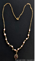 Full view of necklace showing chain, pearls, and pendant