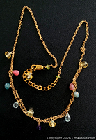 Full view of gold-tone chain necklace with multicolour gemstone drops and clasp