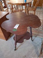 Full view of cloverleaf table showing top, legs, and lower shelf