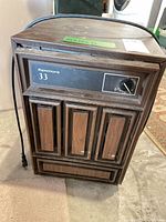 Front view of Kenmore 33 dehumidifier showing control panel, louvered woodgrain front, attached power cord