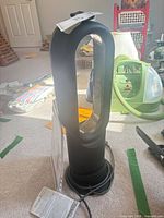 Dyson AM05 fan heater front view with power cord and remote on top