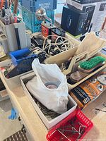 Overview showing tool caddy filled with screwdrivers, cords, shoe care items, timers, light, batteries, wire