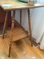 Full view of oak plant stand showing square top, turned legs and lower shelf