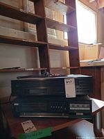 Front view of Yamaha CD player stacked over LXI amplifier