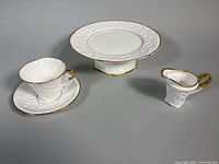 Group view of cake stand, teacup, saucer, creamer