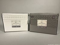Front view of both boxed sheet sets, white and grey