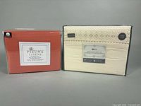 Two sealed queen sheet sets, Pizuna Linens terracotta and embroidered cream