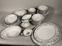 Entire dinnerware set arranged showing platters, bowls, plates, gravy boat, sugar bowl, creamer