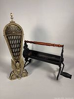 Brass fireplace screen and cast iron log roller side by side