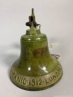 Full view of brass wall bell showing bracket, patina and lettering