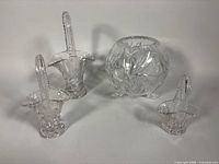 All four glass pieces: footed pinwheel bowl, three pressed glass baskets