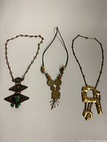 Overview of three necklaces laid out side by side