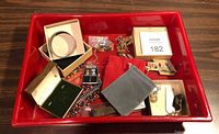 Overall lot in red tray showing mixed jewelry and packaging