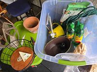 Open tote showing Miracle-Gro bottles, planters, gloves, rope, sprayer, tray, terracotta pot and wire basket