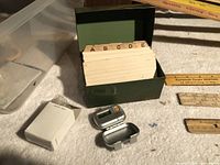 Green index card box with dividers, digital pedometer, yardsticks visible