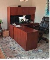 Front view of desk showing hutch, return and office chair for scale