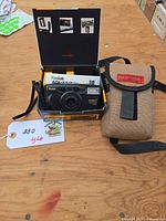 Camera in open original box with manual, carrying case visible beside