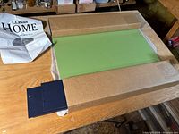 Unboxed green tray panel with navy bracket and instruction sheet