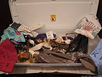 Top view of bin showing assortment of belts, hats, scarves, tops and boots