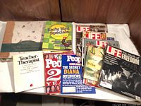 Assorted magazines and a few books laid on table