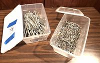Two plastic bins, one with long nails, one with mixed small nails/screws