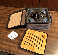Open carry case showing foam insert holding four blue ceramic cups, drip tray alongside