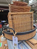 Stack of baskets showing round black-rim tray, wicker baskets and wood basket