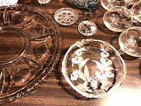 Close-up of deviled egg platter, pressed floral bowl and small dishes