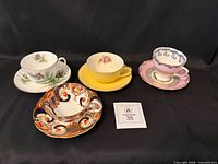 All four teacup and saucer sets grouped together