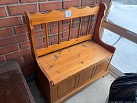 Full view of pine storage bench against brick wall