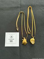 Both necklaces laid flat with lot number card