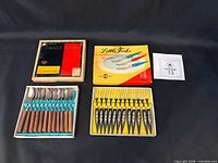 Both boxed utensil sets with lids and lot card visible