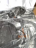 Two jackets in sealed plastic with size stickers visible