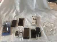 All 7 phones plus sealed Samsung charger and LeYi case laid out