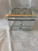 front view showing mirrored finish, crystal chip lid insert, and knobs