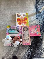 All six items laid out on carpet showing boxes and plushes