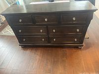 Front view of 7-drawer dresser showing finish, hardware and bun feet