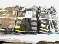 Three sealed packs of Densley & Co. crew socks on table