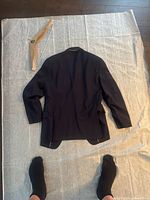 Back view of a dark jacket laid flat on cloth