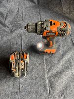 Drill standing upright with one battery beside it