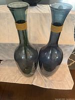 Front view of both tall glass vases showing color and rope collars