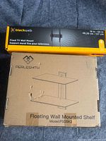 Retail boxes of Perlesmith shelf and Blackweb mount