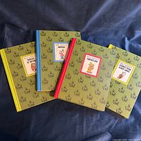 Four Disney Wonderful Worlds hardcovers fanned out showing covers and spine colors