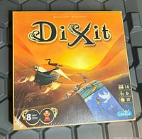 Front of sealed Dixit game box showing artwork and player information