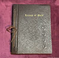 Front cover showing brown textured faux-leather, gilt title, decorative leaf panel, cord binding