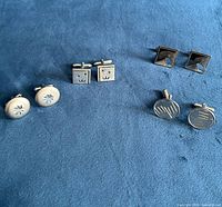 All four pairs of cufflinks laid out for overall view