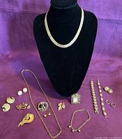 Overview of all jewelry pieces laid out with necklace on bust